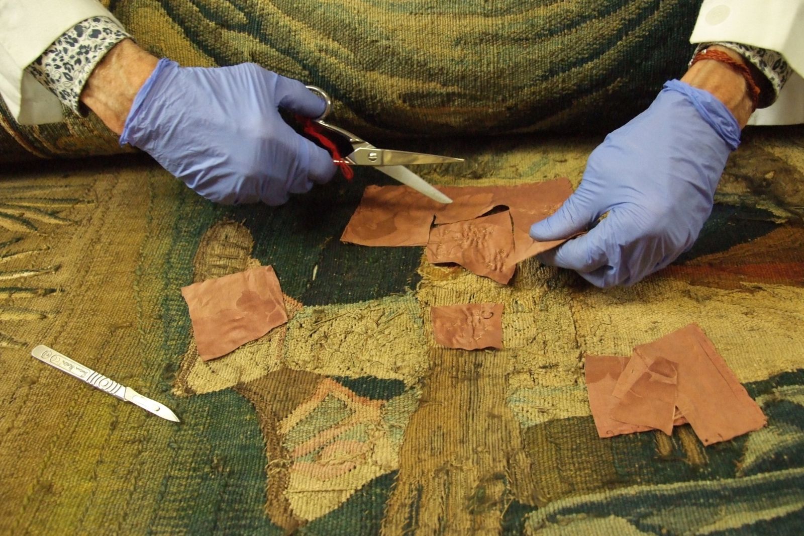 Dépose d’anciennes pièces de restauration sur une tapisserie